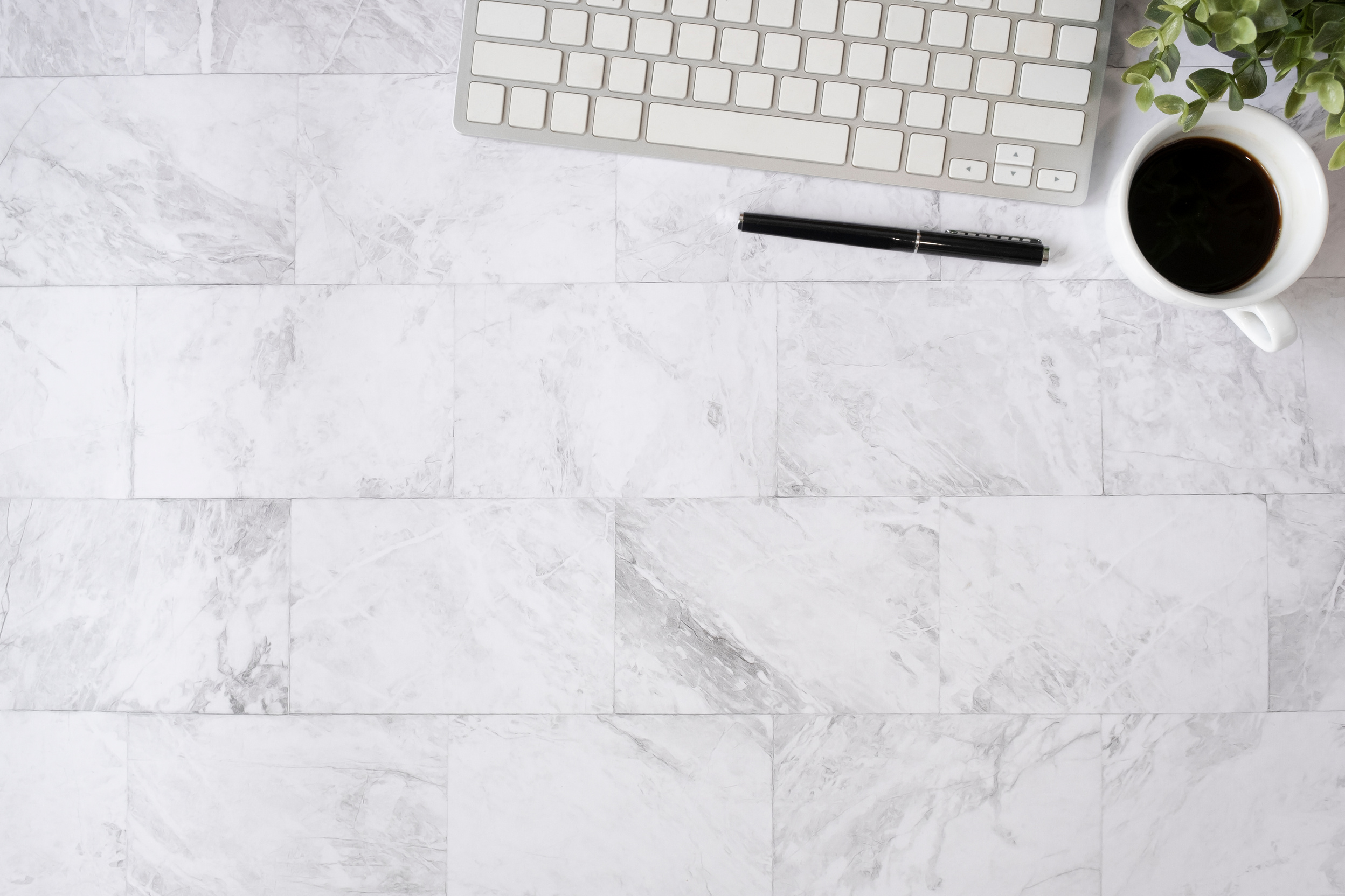 Desk with Keyboard, Pen and Coffee on White Marble Table